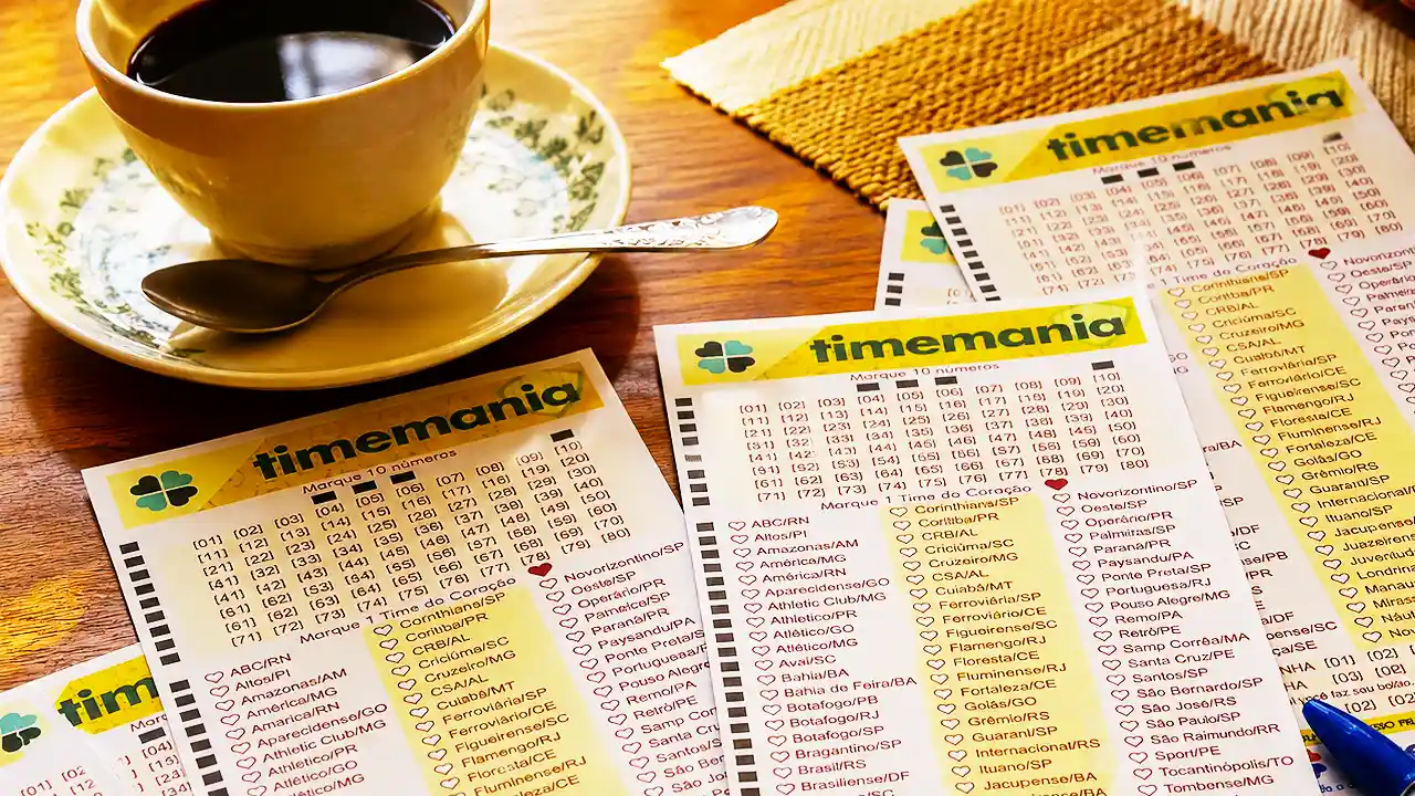 Mesa sobreposta com volantes da lotomania acompanhados de uma xícara com café, pires e colher, para ilustração de reportagem sobre o concurso 2438 da Timemania, com resultado dos números sorteados no domingo, 06/09, bem como prêmios de todas as faixas de acerto. Soma do total de apostas realizadas, e análises econômicas, financeiras e lotéricas tanto sobre as ganhadoras quanto perdedoras, com base na arrecadação.