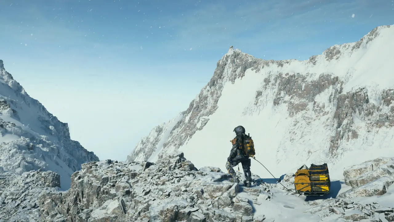 Personagem de Death Stranding 2 atravessa cenário montanhoso coberto de neve. Personagem de Death Stranding 2 atravessa cenário montanhoso coberto de neve.