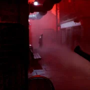 Jogador aponta arma em ambiente tomado por luz vermelha em Silent Hill: Townfall.