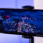 Smartphone em suporte exibindo um jogo durante demonstração de tecnologia Snapdragon.