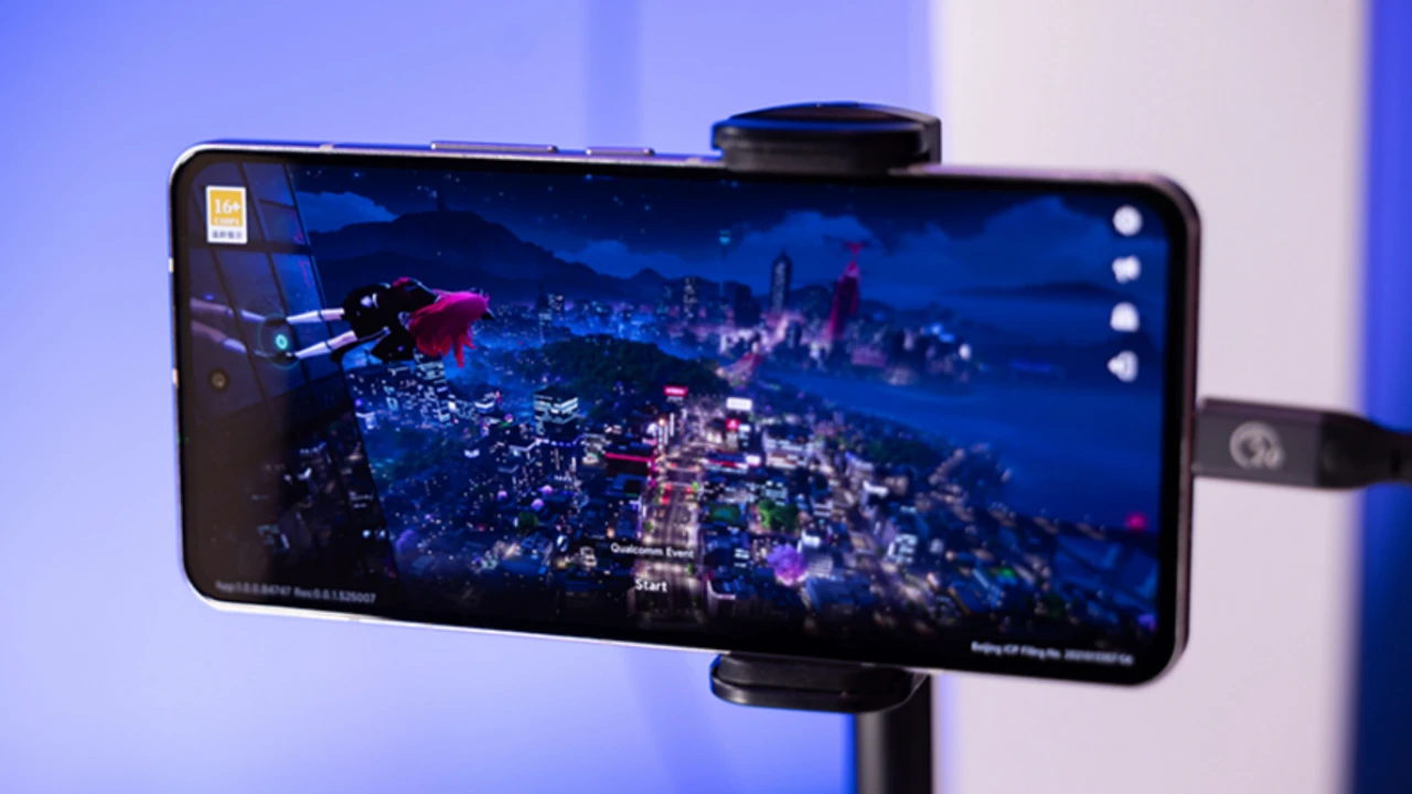 Smartphone em suporte exibindo um jogo durante demonstração de tecnologia Snapdragon.