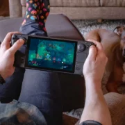 Pessoa joga no Steam Deck OLED enquanto segura o portátil da Valve.