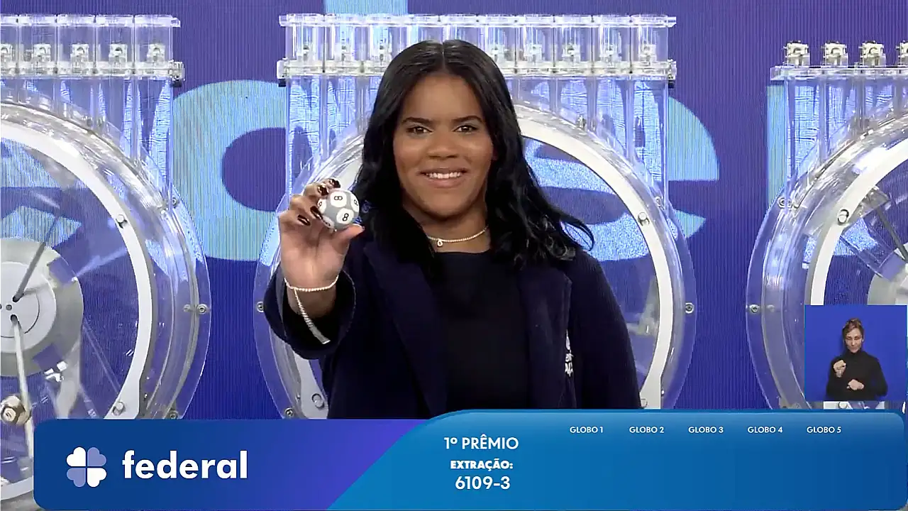 Garota da Sorte exibe bola ejetada do globo durante sorteio que formou o resultado completo de todos os prêmios do concurso 6109 da Loteria Federal, referente à Extração de quarta-feira, 14/10, com todas as dezenas de milhar do 1º, 2º, 3º, 4º, 5º prêmio, bem como premiações derivadas | Reprodução