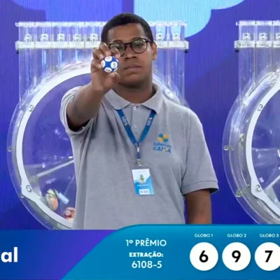 Funcionário da Caixa exibe bola ejetada do globo durante sorteio que formou o resultado completo de todos os prêmios do concurso 6108 da Loteria Federal, referente à Extração de Domingo, 11/10, com todas as dezenas de milhar do 1º, 2º, 3º, 4º, 5º prêmio, bem como premiações derivadas