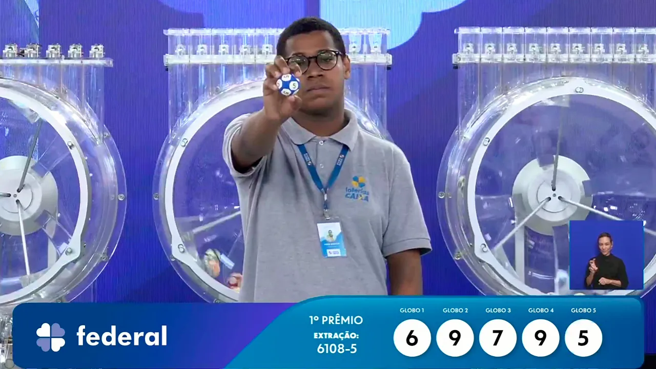Funcionário da Caixa exibe bola ejetada do globo durante sorteio que formou o resultado completo de todos os prêmios do concurso 6108 da Loteria Federal, referente à Extração de Domingo, 11/10, com todas as dezenas de milhar do 1º, 2º, 3º, 4º, 5º prêmio, bem como premiações derivadas