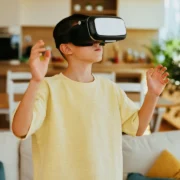 Pessoa utiliza óculos de realidade virtual em uma sala de estar, ilustrando a necessidade de espaço livre para jogos VR.