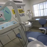 Profissional de odontologia realiza atendimento a paciente em consultório odontológico.