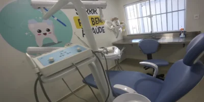 Profissional de odontologia realiza atendimento a paciente em consultório odontológico.