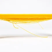 Peça de teste de impressão 3D com linhas de filamento suspensas entre dois pilares, demonstrando a técnica de bridging.