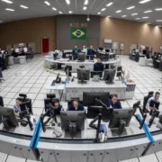 Controladores de tráfego aéreo da FAB trabalham em torre de controle, utilizando rádio e monitores para acompanhar movimentos de aeronaves.