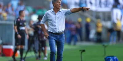 Renato Portaluppi, técnico do Grêmio, aponta para o campo e orienta a equipe à beira do gramado durante partida de futebol.