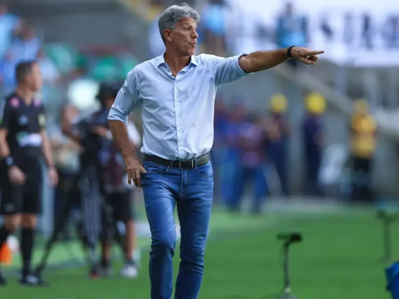 Renato Portaluppi, técnico do Grêmio, aponta para o campo e orienta a equipe à beira do gramado durante partida de futebol.