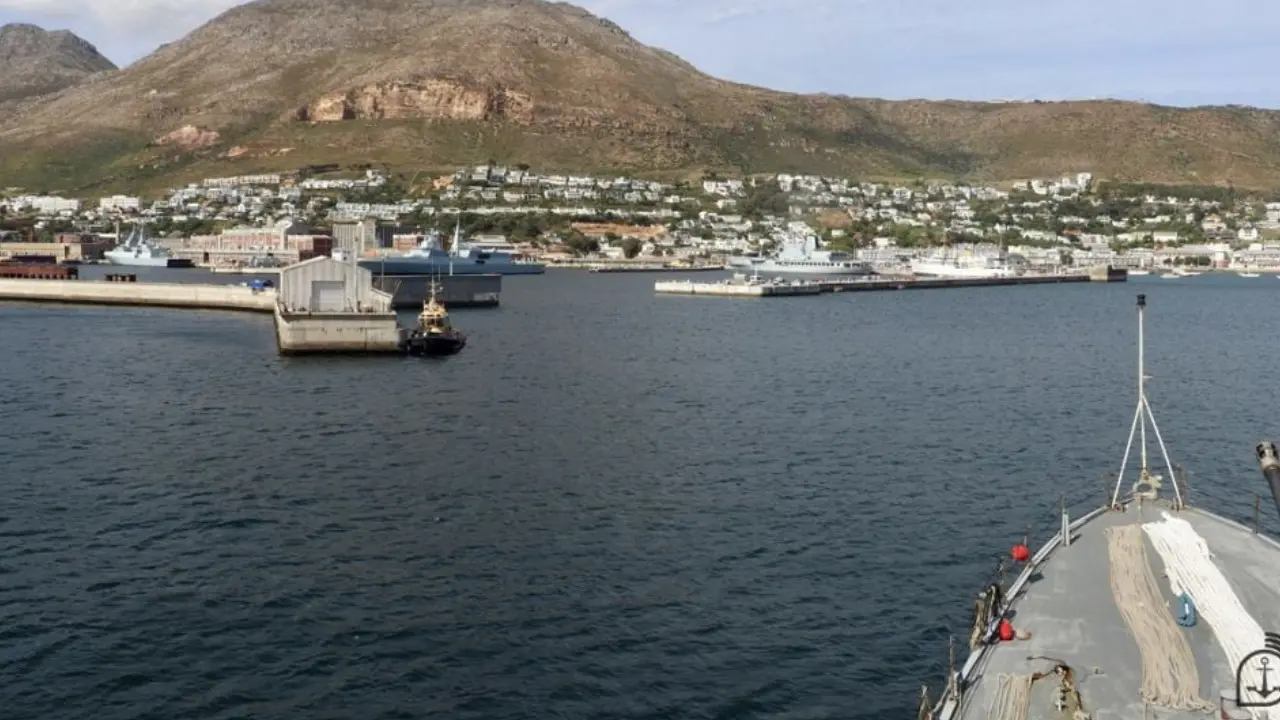 Vista da Base Naval de Simon’s Town, na África do Sul, com navios militares atracados, instalações portuárias e montanhas ao fundo. Vista da Base Naval de Simon’s Town, na África do Sul, com navios militares atracados, instalações portuárias e montanhas ao fundo.