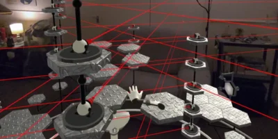 Duas mãos virtuais controladas por rastreamento em um cenário de plataformas do jogo Disembodied.