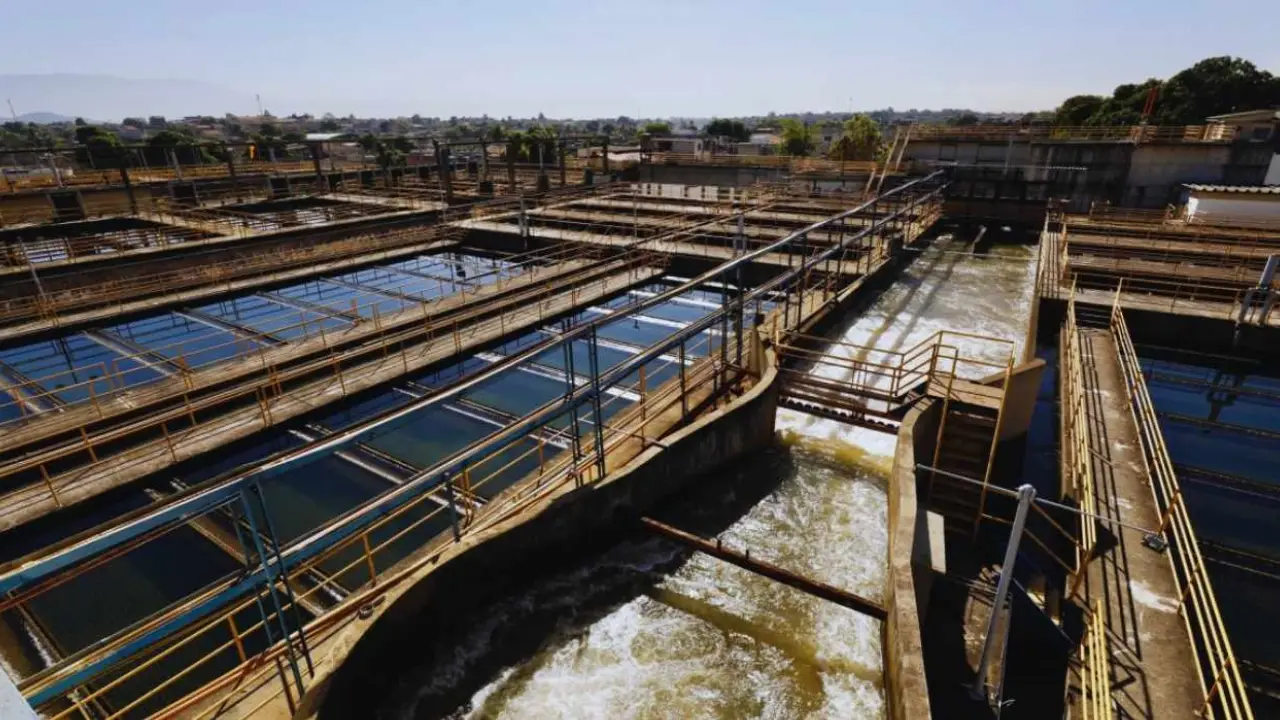 Estrutura de estação de tratamento de água, com tanques, passarelas metálicas e canais de circulação de água.