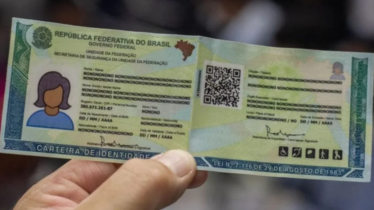Mão segura modelo ilustrativo de carteira de identidade brasileira, com QR Code, fotografia representativa e dados pessoais fictícios. Mão segura modelo ilustrativo de carteira de identidade brasileira, com QR Code, fotografia representativa e dados pessoais fictícios.