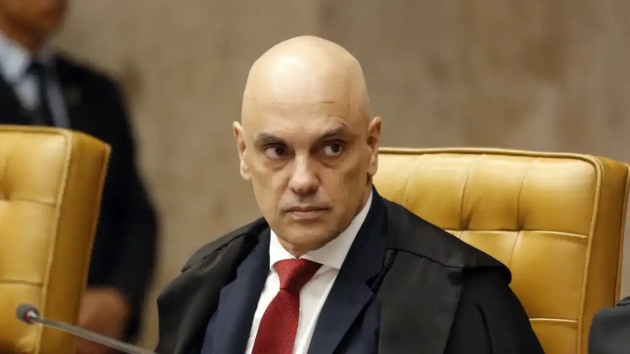 Ministro Alexandre de Moraes, do Supremo Tribunal Federal, sentado no plenário do STF, usando toga preta e gravata vermelha.