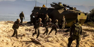 Fuzileiros Navais brasileiros participam de exercício de desembarque anfíbio com veículos militares em área litorânea.