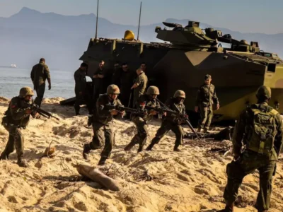 Fuzileiros Navais brasileiros participam de exercício de desembarque anfíbio com veículos militares em área litorânea.