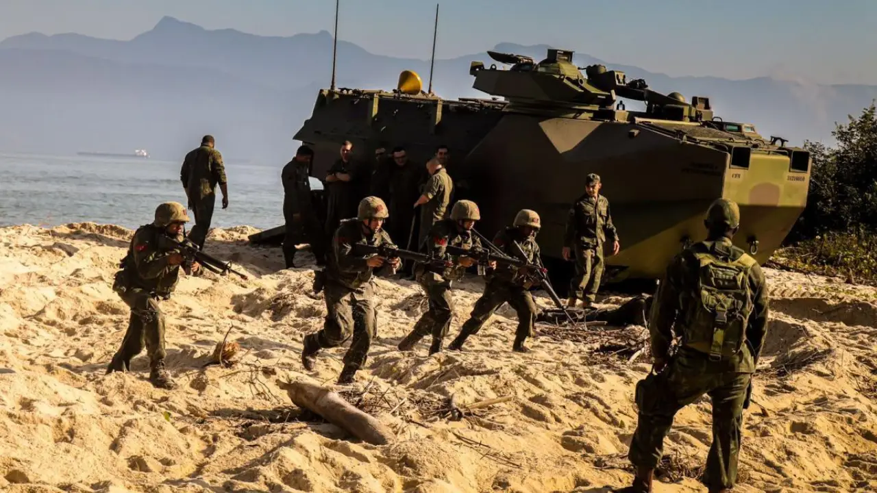 Fuzileiros Navais brasileiros participam de exercício de desembarque anfíbio com veículos militares em área litorânea.