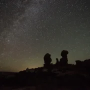 Céu estrelado sobre formações rochosas durante a noite
