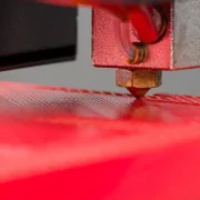 Bico de impressora 3D sobre a superfície de impressão, ilustrando a técnica ironing para melhorar o acabamento de peças.