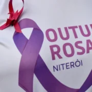 Mulher realiza mamografia com auxílio de profissional de saúde