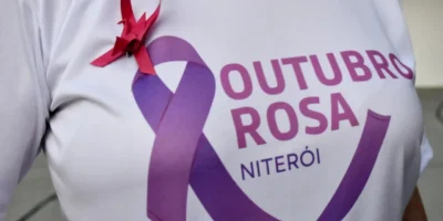 Mulher realiza mamografia com auxílio de profissional de saúde