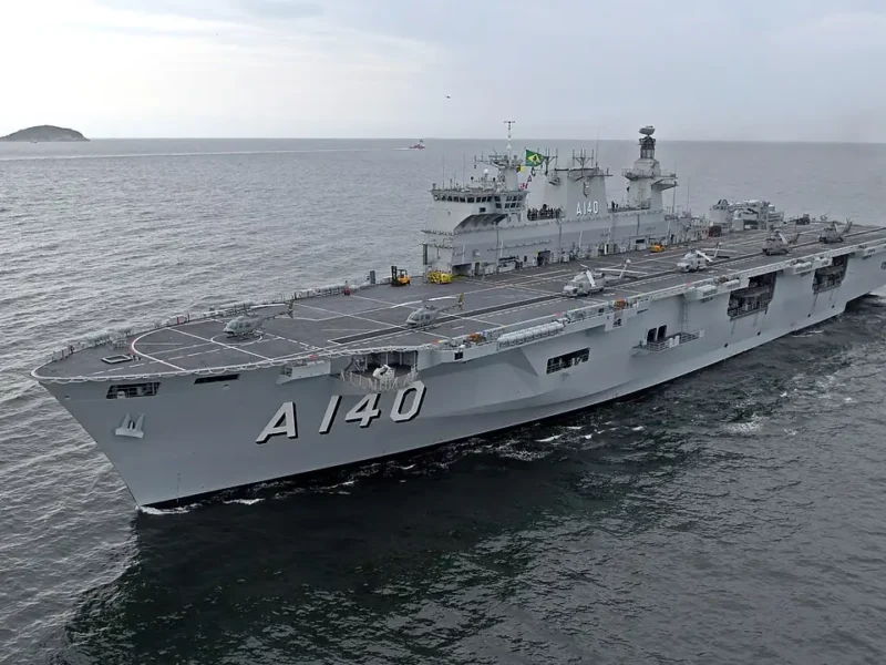 Navio-Aeródromo Multipropósito Atlântico (A140), da Marinha do Brasil, navegando com helicópteros posicionados no convés de voo.