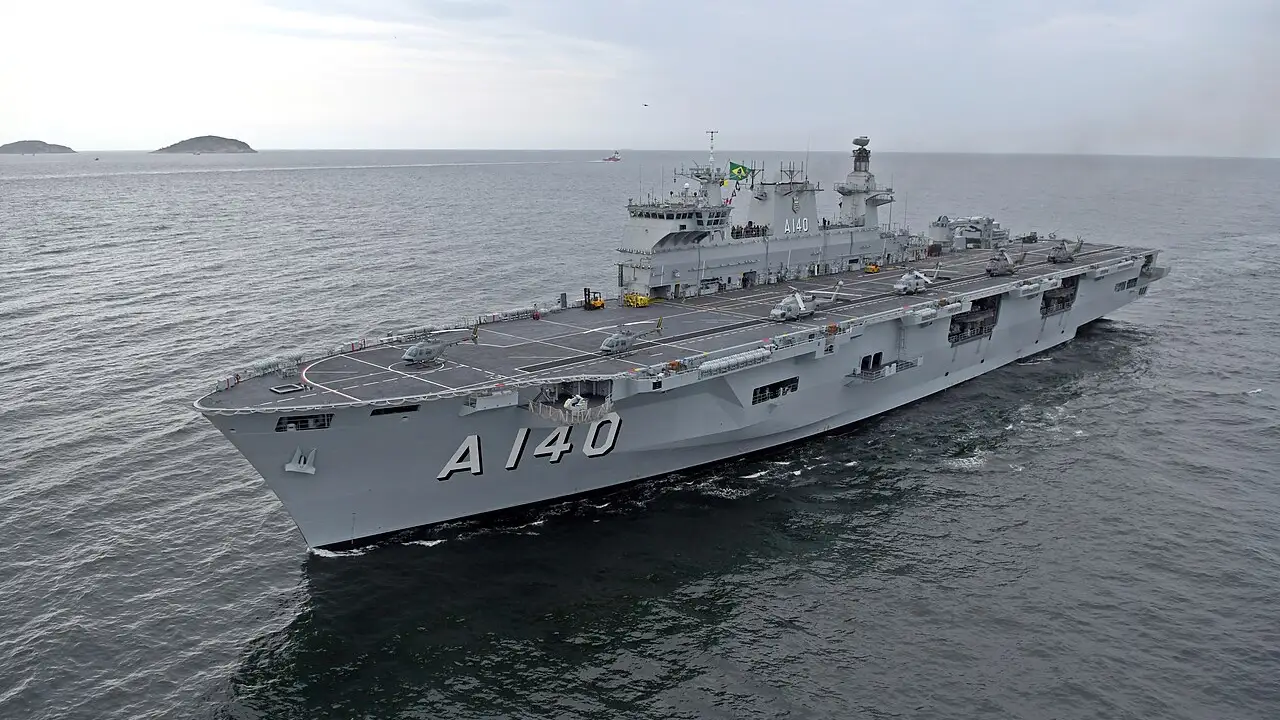 Navio-Aeródromo Multipropósito Atlântico (A140), da Marinha do Brasil, navegando com helicópteros posicionados no convés de voo.