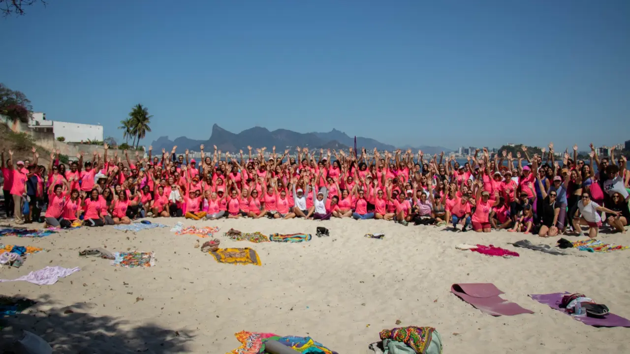 Mulheres reunidas na praia durante ação do Outubro Rosa em Niterói