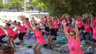 Mulheres participam de aula de Yoga na praia durante programação do Outubro Rosa em Niterói