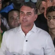 Flávio Bolsonaro, de camisa branca, fala à imprensa diante de um grupo de apoiadores após o segundo turno das eleições presidenciais.