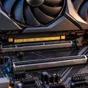 Placa de vídeo com conectores dourados posicionada sobre slots PCI Express de uma placa-mãe, ilustrando conexões PCIe x8 e x16.