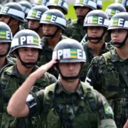 Soldados da Polícia do Exército Brasileiro em formação, utilizando uniformes camuflados e braçais pretos identificados com as letras PE.