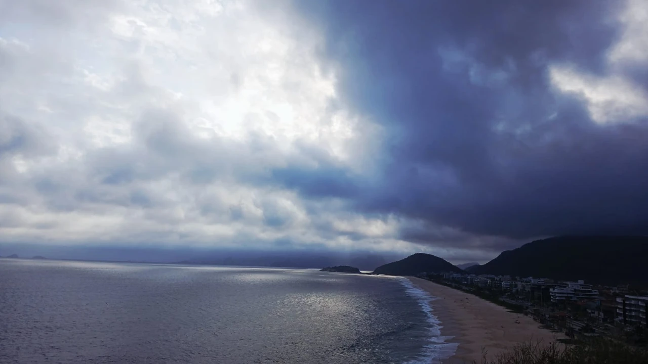 Praia de Piratininga, em Niterói, com nuvens escuras no céu, ilustrando a previsão de chuva e ventos fortes. Praia de Piratininga, em Niterói, com nuvens escuras no céu, ilustrando a previsão de chuva e ventos fortes.