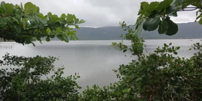 Vista panorâmica de Niterói com céu nublado, ilustrando a previsão de tempestade neste domingo.