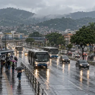 Avenida movimentada sob chuva em São Gonçalo, com ônibus, carros e pedestres