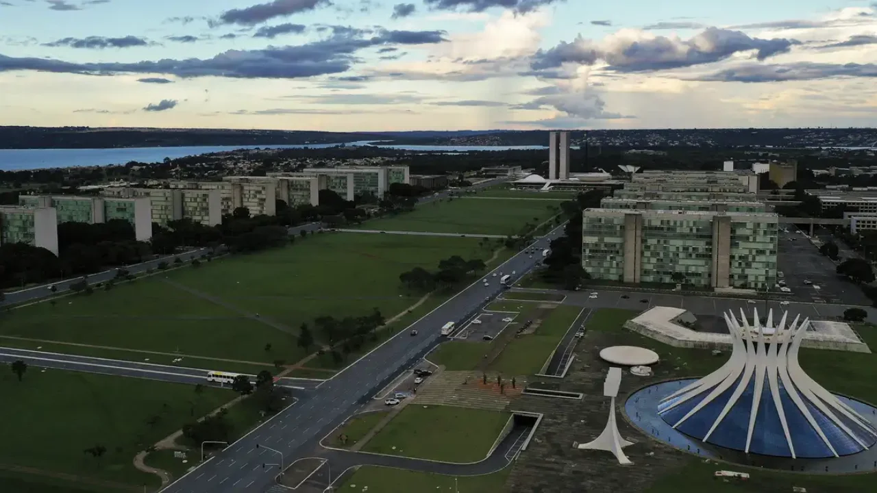 Vista aérea da Esplanada dos Ministérios, em Brasília, com a Catedral Metropolitana, edifícios do governo federal e o Congresso Nacional ao fundo.